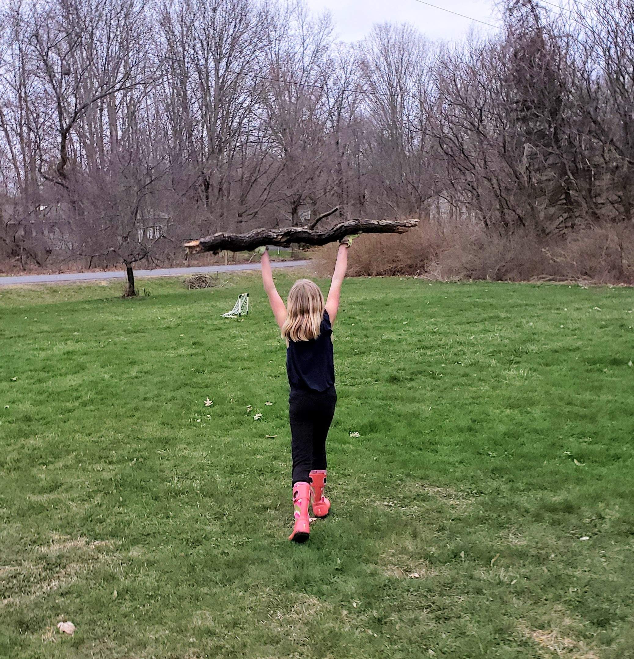 girl carrying a big log over her head