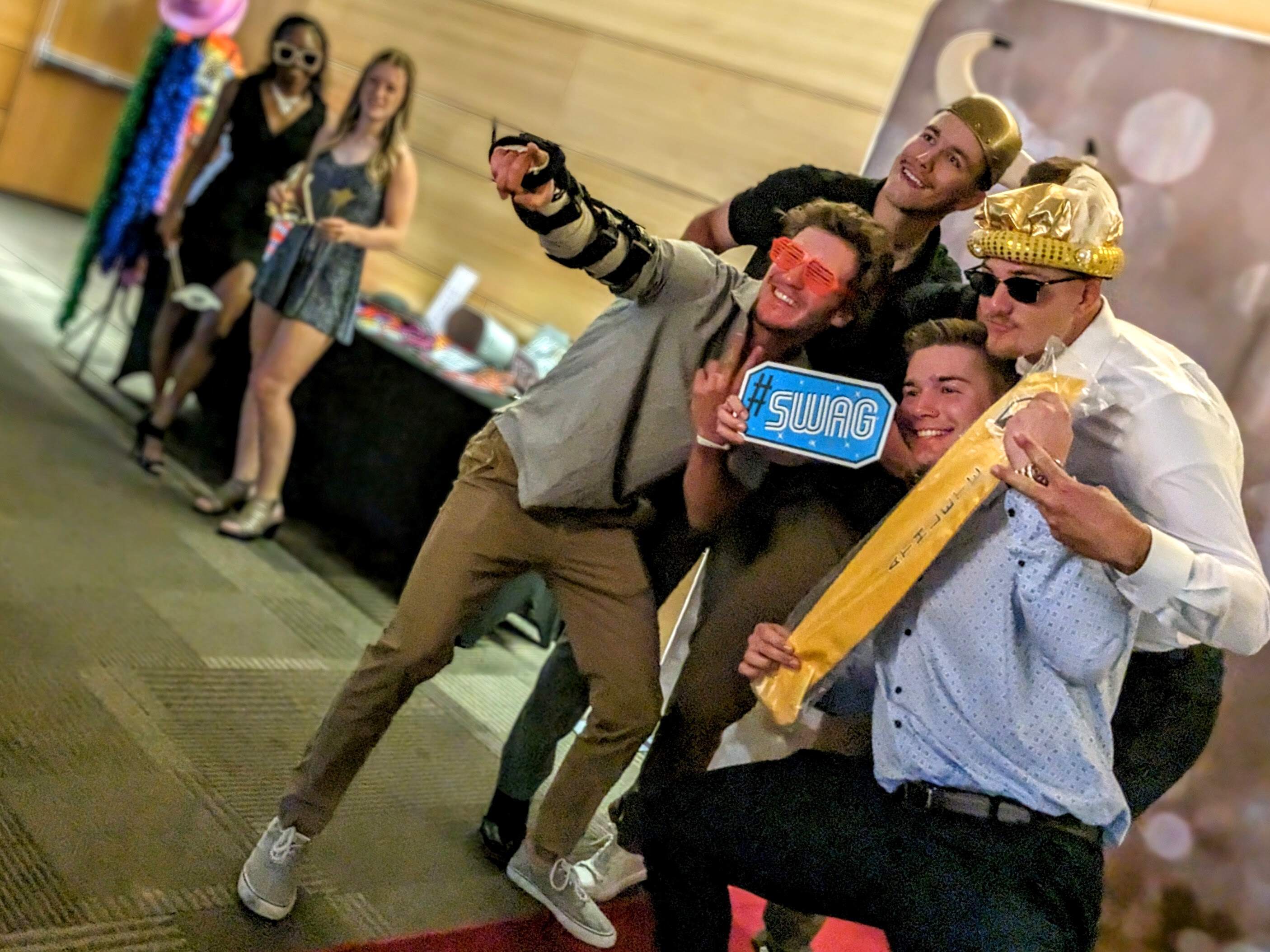 Group of friends posing with props at a fun-filled event photo booth.