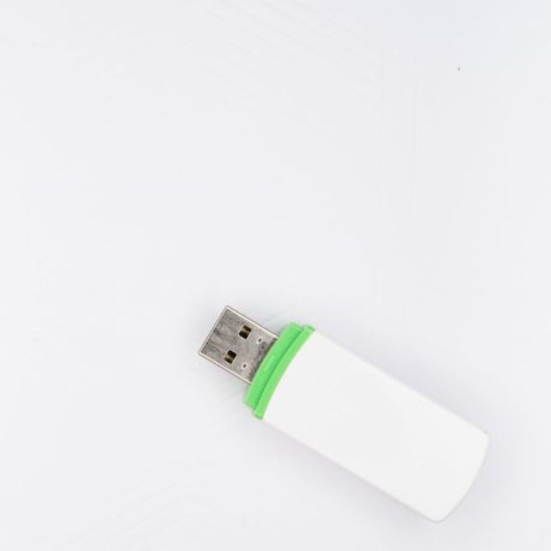 White and green USB drive used for storing photo booth images from an event.